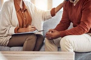 Woman comforts another during an anxiety treatment program therapy session