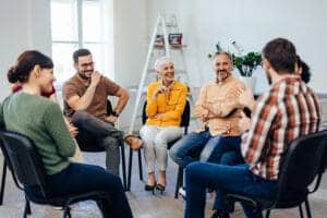 People sit in a circle while talking in group therapy