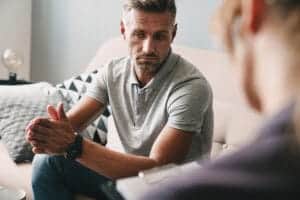 Man sits on couch and talks to therapist about his meth use during a meth addiction treatment program