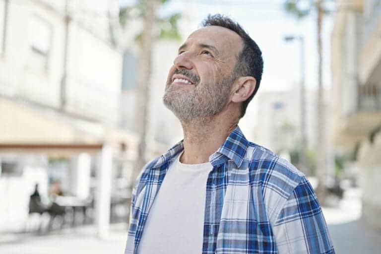 Man looks at sky while pondering the best way to prevent relapse